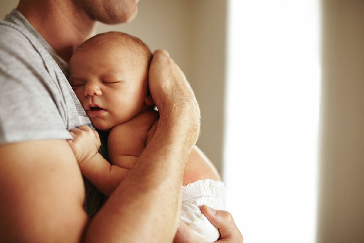 dad cuddling sleeping baby